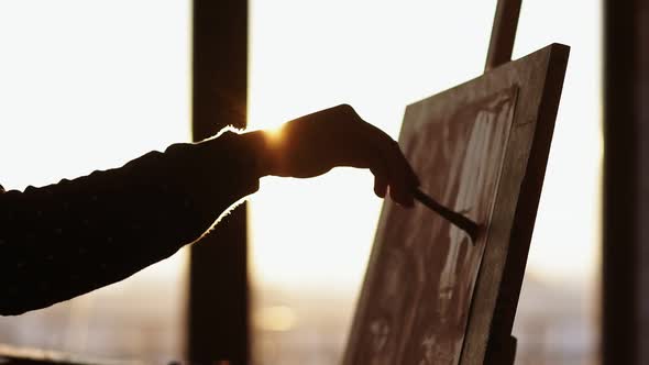 Female Artist Hand Filling Out the Space on the Canvas with Paint