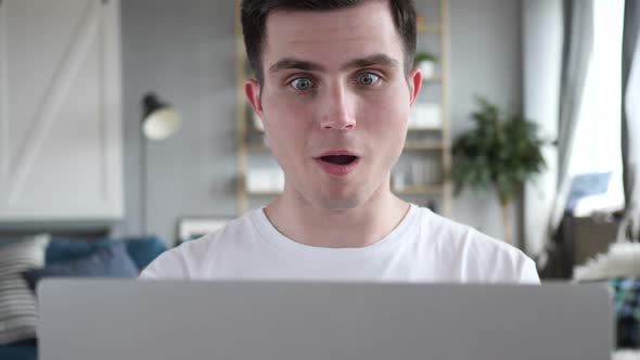 Close Up of Shocked Man Wondering and Working on Laptop