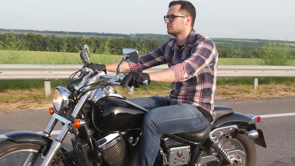 Serious Man with Glasses on a Motorcycle. Overhead Shot