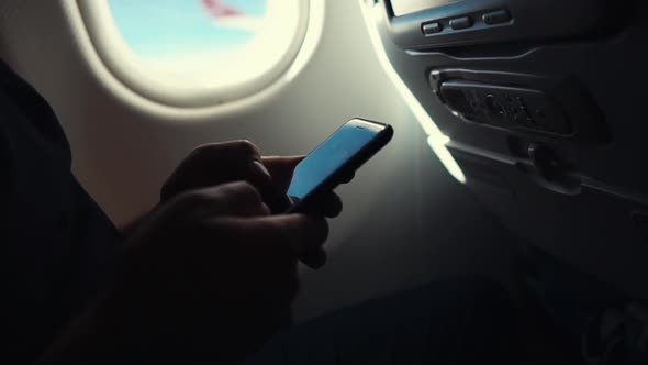 Man Using Smartphone on a Plane,