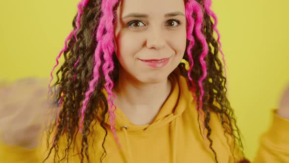 Young Beautiful Woman with Curly Hairstyle Smiling and Dancing on Yellow Background