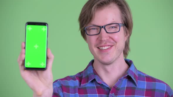 Face of Happy Young Handsome Hipster Man Showing Phone