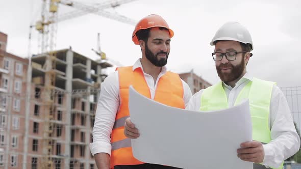 Smiling Male Construction Engineer Discussion with Architect at Construction Site or Building Site