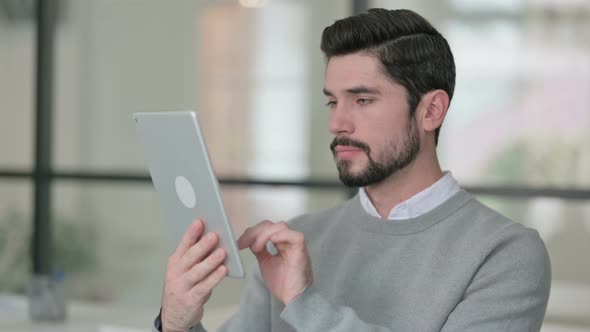 Portrait of Attractive Young Man Using Tablet in Office