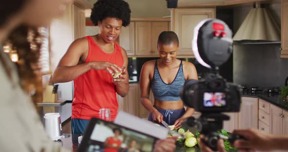 Diverse group of friends making culinary vlog in kitchen