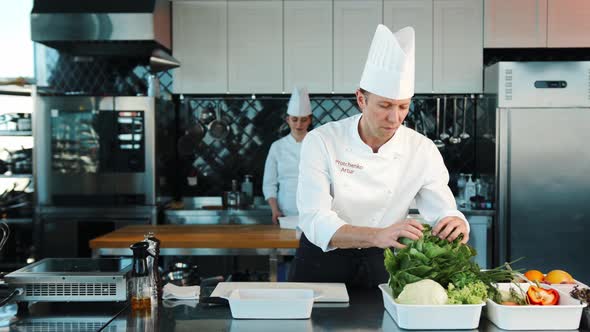Professional restaurant kitchen, portrait of chefs Men and women Chef's assistant brings ingredients