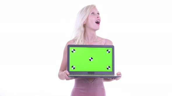 Happy Young Beautiful Blonde Woman Thinking While Showing Laptop