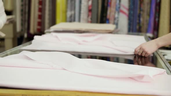 A Fabric Store Worker Cuts Off the Necessary Piece of Fabric for the Client