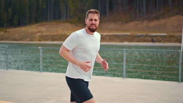 Young man running fast and intense in forest