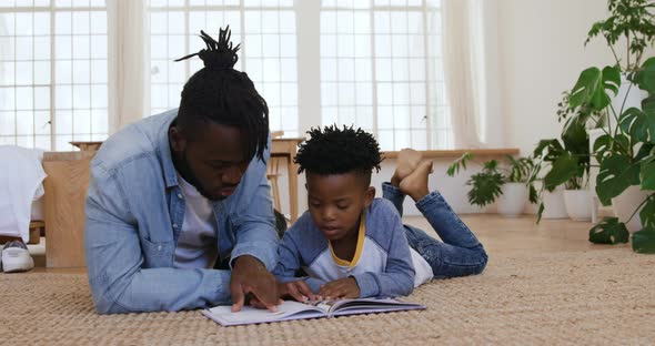 Father and son reading a book together at home