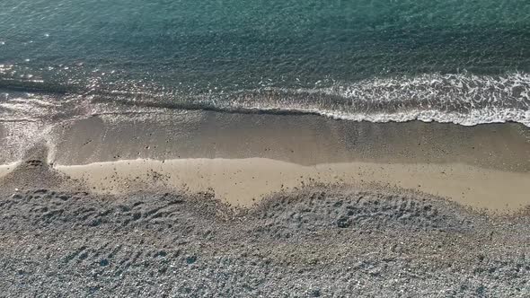 Top View of Clear Water Sea Waves Hitting Sandy Beach