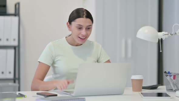 Young Latin Woman with Laptop Celebrating Success