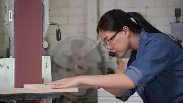 Young woman use electric rubbing to surface wood