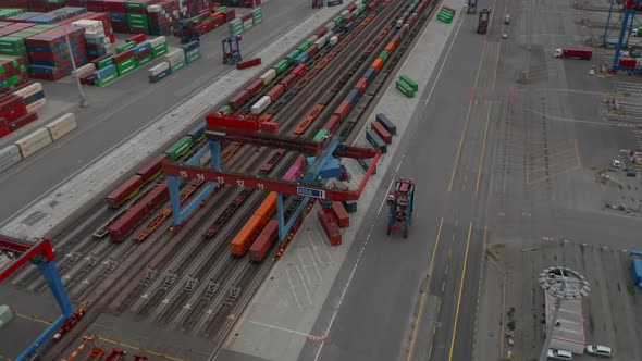Aerial View of Forklift Driving in Commercial Cargo Terminal By Colorful Cargo Containers