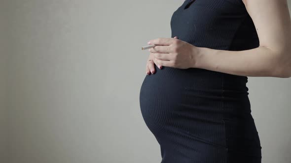 Smoking Girl with a Cigarette with a Big Belly During Pregnancy