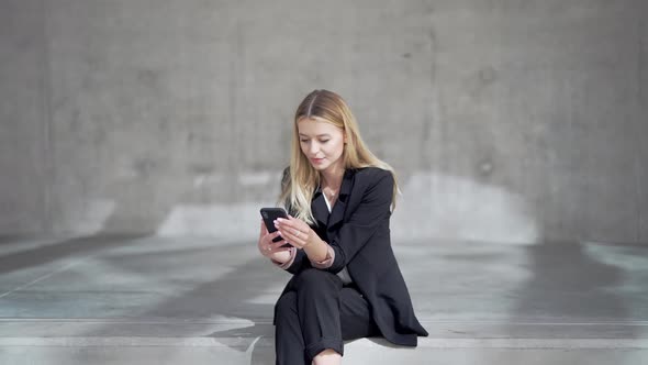 Smiling Businesswoman with Her Smartphone