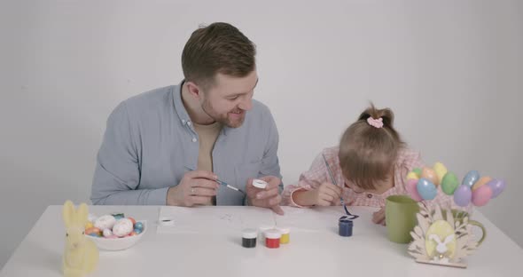 Girl with Down Syndrome Painting Easter Eggs with Father