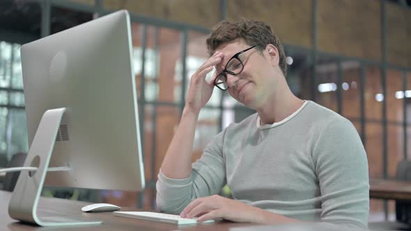 Tired Guy Having Headache While Working on Desktop