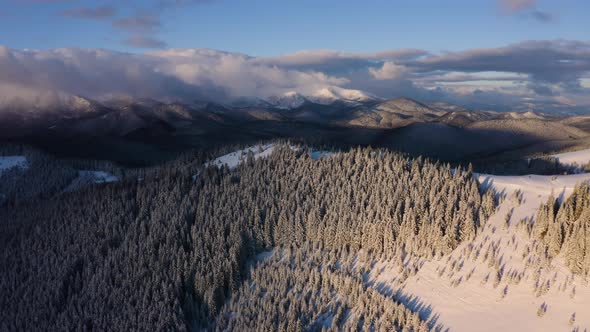 Epic Aerial Scenery in Winter Mountains. Stormy Clouds Cover Mountains. Flyover