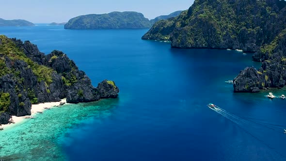 Wide Aerial panof boat passing Shimizu island. El Nido, Palawan, Philippines