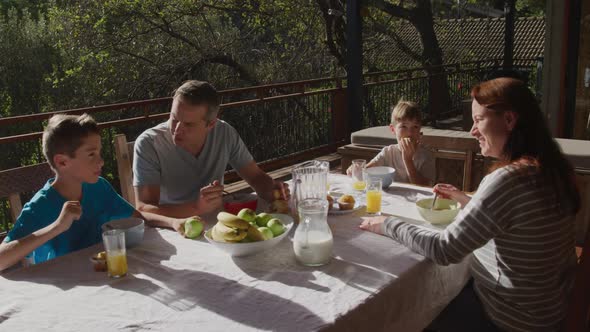 Family eating breakfast together outdoors