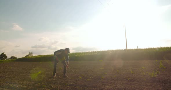 Angry Farmer Throwing Hoe on Field in Farm