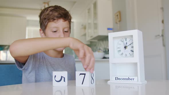 Boy Flips Handmade Wood Cubes with with Numbers 31 December