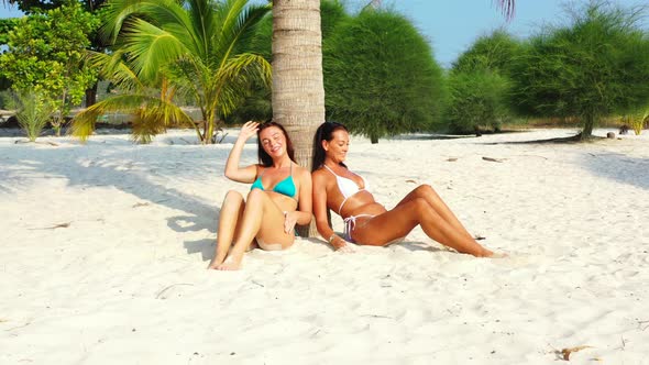 Modern beauty models on vacation enjoying life on beach on sunny blue and white sand background 