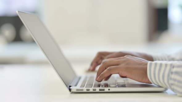 Close Up of African Man Typing on Laptop