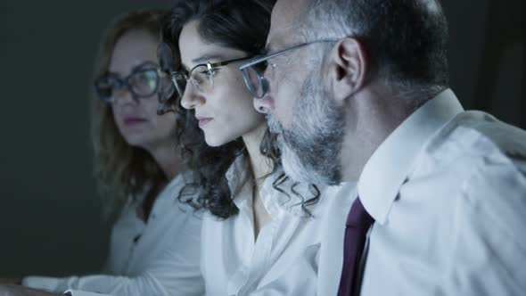 Coworkers Discussing Work in Dark Office