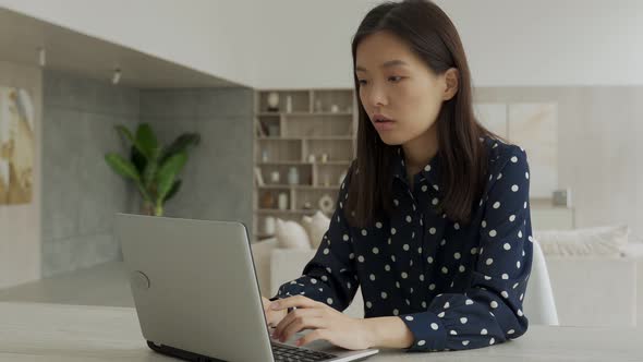 Asian Businesswomanentrepreneur Using a Computer Looking at a Screen Working at an Office Desk a