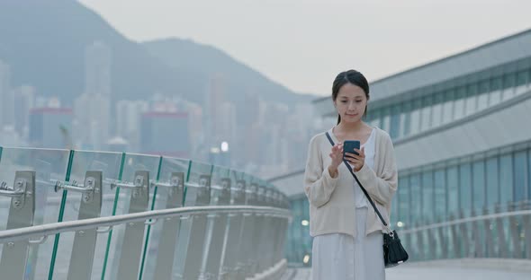 Woman look at mobile phone in Hong Kong city