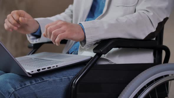 Man in a Wheelchair Working on Laptop