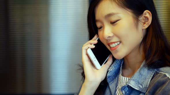 Businesswoman talking on the phone inside a meeting room at office.