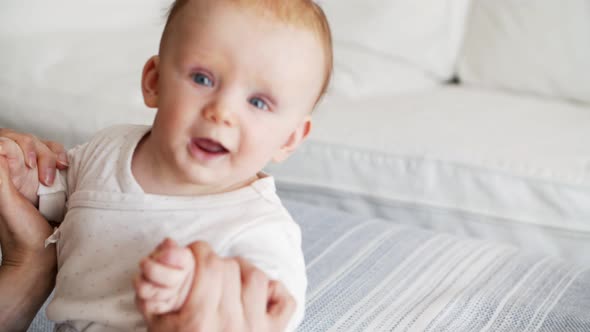 Mom Helping Baby Daughter To Sit Up