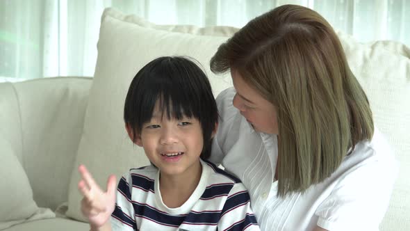 Asian Child And His Mother Talking Together