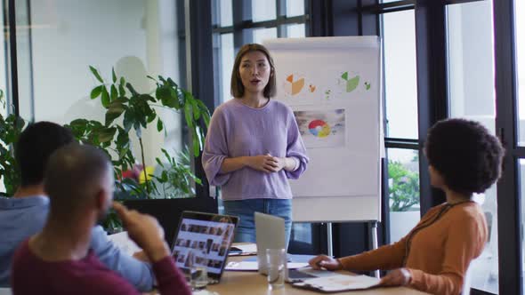 Diverse business people sitting listening to a presentation in office