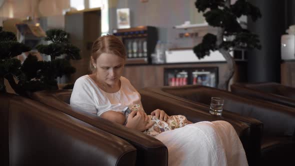 Mother Breastfeeding Baby in Hotel Hall
