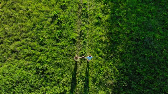 Aerial Drone Footage, Young People Run Across the Field