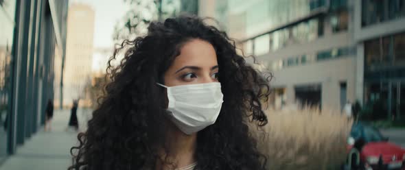 Video of woman in protective mask walking on the street. Shot with RED helium camera in 8K.