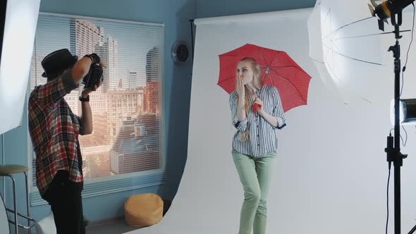 Behind the Scenes on Photo Shoot Attractive Caucasian Model Posing with Red Umbrella