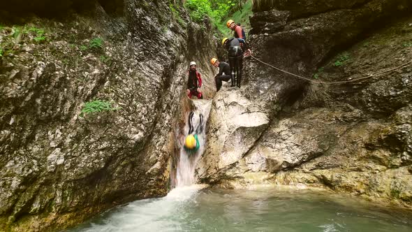 Aerial view of man throwing himself through a sliding rock at Soca river.