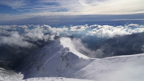 Snowy Alpine Mountains in Sunny Winter Above Clouds