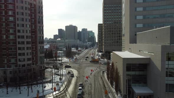 Aerial forward view of a city road with cars parked and people walking by. Ottawa. Canada