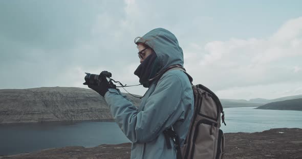 Woman takes photo on the top of a mountain