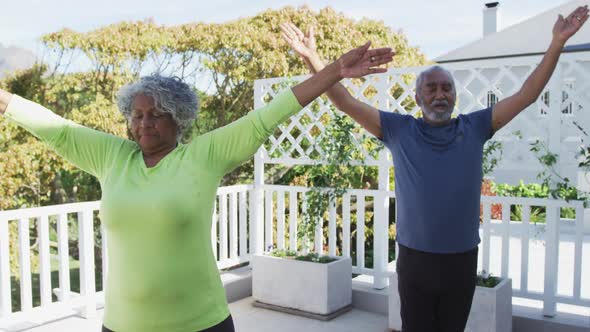 Animation of relaxed african american senior couple practicing yoga on patio