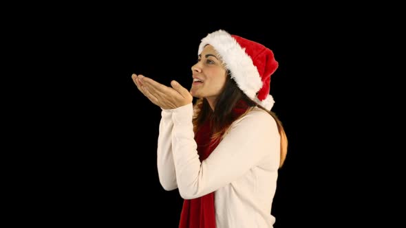 Woman in santa hat and warm clothing blowing over hands