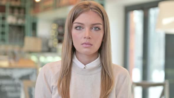 Portrait of Serious Young Woman Looking at the Camera