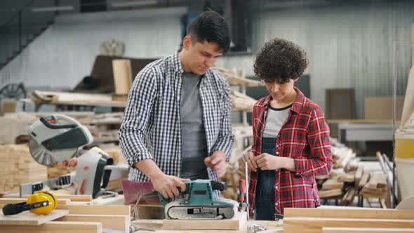 Handsome Guy Teaching New Worker Apprentice To Use Polishing Machine at Factory