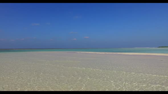 Aerial above scenery of tranquil seashore beach wildlife by blue lagoon and white sandy background o